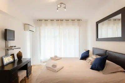 a bedroom with a large bed with blue pillows at 2-Br Apartment 2 min from the Beaches in Cannes