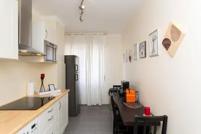 a kitchen with a counter top and a table and a refrigerator at 2-Br Apartment 2 min from the Beaches in Cannes