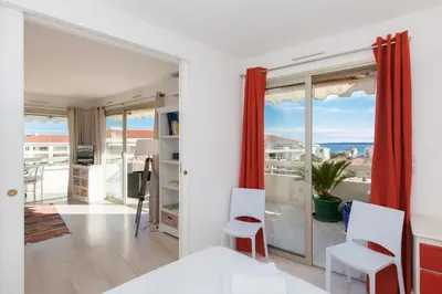 a bedroom with white walls and a large glass window at High-Standard 2-Bedroom Apartment with Sea View and Large Terrace in Cannes