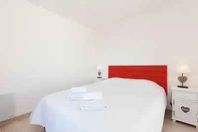 a bedroom with a white bed with two towels on it at High-Standard 2-Bedroom Apartment with Sea View and Large Terrace in Cannes