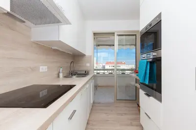 a kitchen with white cabinets and a large window at High-Standard 2-Bedroom Apartment with Sea View and Large Terrace in Cannes