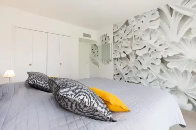 a bedroom with a bed with pillows on it at 2-Br apartment 2 minutes from the beach parking in Cannes