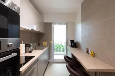 a kitchen with white counters and a large window at 2-Br apartment 2 minutes from the beach parking in Cannes