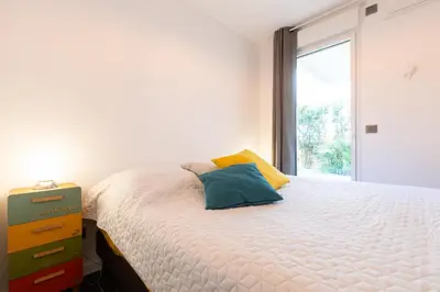 a bedroom with a large bed and a window at 2-Br with Garden and Pool in the Heart of Palm Beach in Cannes