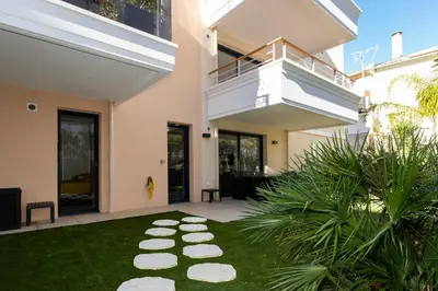a house with a garden with rocks on the grass at 2-Br with Garden and Pool in the Heart of Palm Beach in Cannes