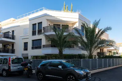 a car parked in front of a white building at 2-Br with Garden and Pool in the Heart of Palm Beach in Cannes