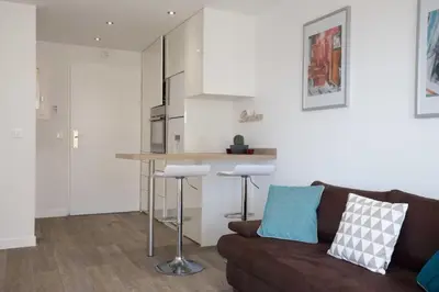 a living room with a couch and a kitchen at Haven of Peace 1-Br Terrace with Sea View & Pool in Cannes