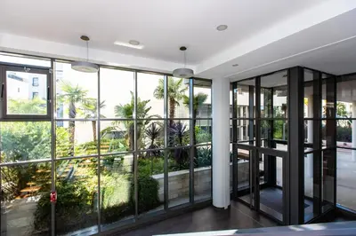 a room with large windows looking out at palm trees at Renovated 2-Br Apartment with Terrace and Pool in Cannes