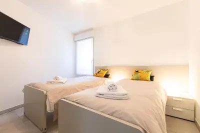a bedroom with two beds with towels on them at Renovated 2-Br Apartment with Terrace and Pool in Cannes