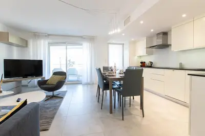 a kitchen and living room with a table and chairs at Renovated 2-Br Apartment with Terrace and Pool in Cannes