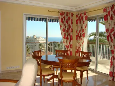 a dining room with a table and chairs and a large window at The Best Place in Cannes