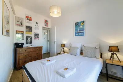 a bedroom with a large white bed with two towels on it at Joli appartement à côté du Palais des Festivals in Cannes