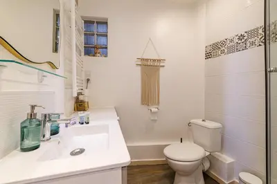 a white bathroom with a toilet and a sink at Joli appartement à côté du Palais des Festivals in Cannes
