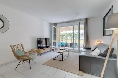 a living room with a couch and a chair at Appartement Palais Milton in Cannes