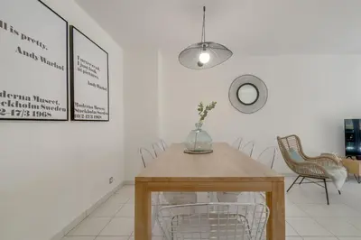 a dining room with a wooden table and chairs at Appartement Palais Milton in Cannes