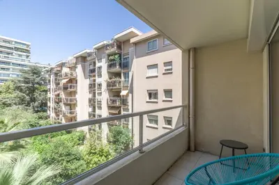 a balcony with two chairs and a building at Appartement Palais Milton in Cannes