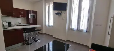 a kitchen with a counter and a sink and windows at One Bedroom André in Cannes