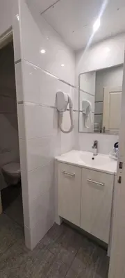 a white bathroom with a sink and a mirror at One Bedroom André in Cannes