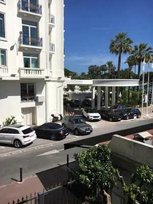 a parking lot with cars parked in front of a building at Appartement Le Palais Des Iles in Cannes