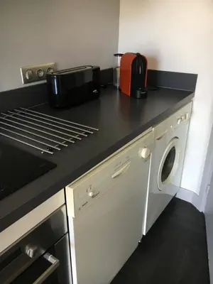 a kitchen with a black counter top with a appliance at Appartement Le Palais Des Iles in Cannes