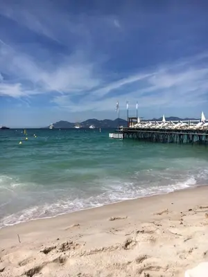 a beach with a pier in the water at Appartement Le Palais Des Iles in Cannes