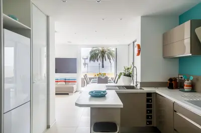 a kitchen with white countertops and a living room at PLAGE Ground floor apartment on seafront with large terrace in Cannes