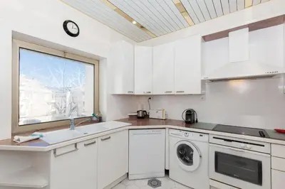 a kitchen with white cabinets and a sink and a window at Sea View Cannes Croisette in Front of the Sea in Cannes