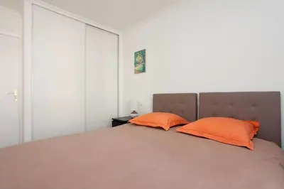 a bedroom with a bed with two orange pillows at 3-Room Apartment with Terrace in Palm Beach in Cannes