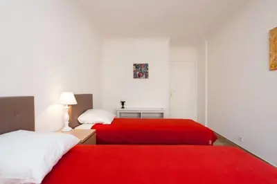 two beds in a white room with red sheets at 3-Room Apartment with Terrace in Palm Beach in Cannes