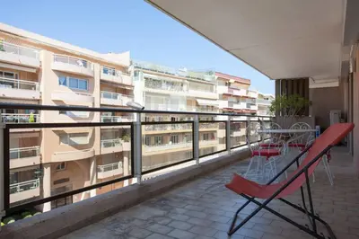 a balcony with a table and chairs and a building at 3-Room Apartment with Terrace in Palm Beach in Cannes