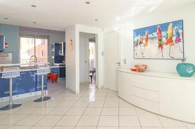 a kitchen with a counter with a painting on the wall at Superb Bright Apartment with Sea View in Cannes