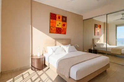 a bedroom with a large white bed and a mirror at Superb Bright Apartment with Sea View in Cannes