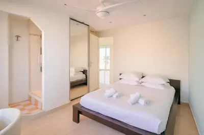 a bedroom with a white bed and a mirror at Superb Bright Apartment with Sea View in Cannes