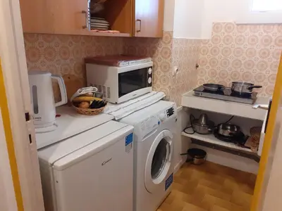 a kitchen with a microwave and a washing machine at Stella Apartment - Cannes in Cannes