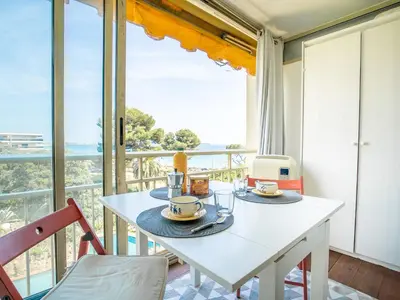 a dining room with a table and a balcony at Apartment Le Trident by Interhome in Cannes