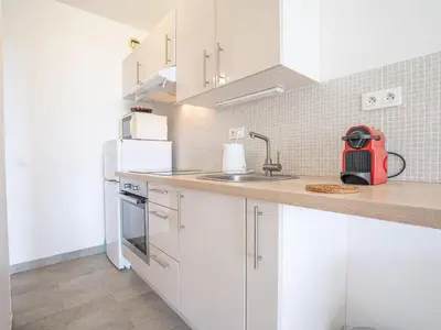 a kitchen with white cabinets and a sink at Apartment Le Trident by Interhome in Cannes