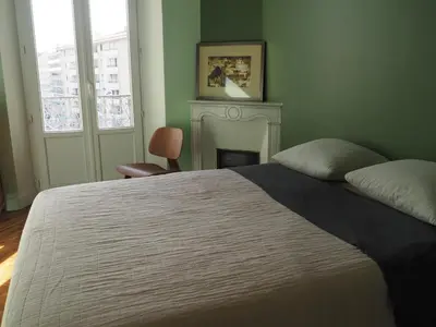 a kitchen with a wooden table and some black cabinets at GRAND TROIS PIECES QUARTIER CROISETTE in Cannes