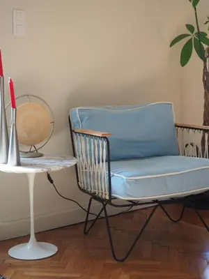 a blue chair sitting next to a table with a plant at GRAND TROIS PIECES QUARTIER CROISETTE in Cannes