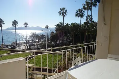 a balcony with a view of the ocean and palm trees at Rocamare 2, by Welcome to Cannes in Cannes