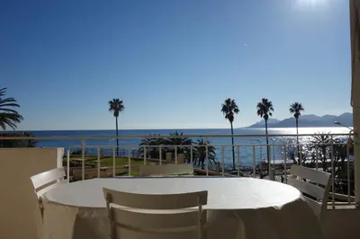 a table with chairs and a view of the ocean at Rocamare 2, by Welcome to Cannes in Cannes