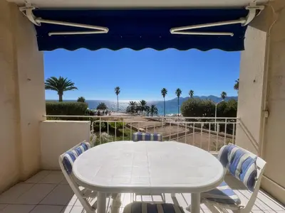 a table and chairs on a balcony with a view of the ocean at Rocamare 2, by Welcome to Cannes in Cannes