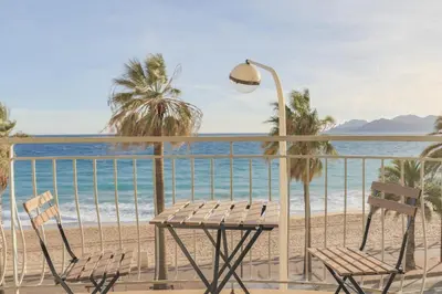 a table and chairs on a balcony overlooking the beach at IMMOGROOM - SEA VIEW - 2 min from beach - CONGRESSBEACHES in Cannes