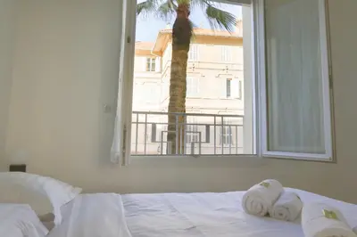 a bedroom with a bed with towels and a window at IMMOGROOM - SEA VIEW - 2 min from beach - CONGRESSBEACHES in Cannes