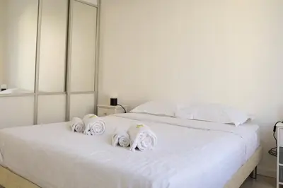 a white bed with three rolled towels on it at IMMOGROOM - SEA VIEW - 2 min from beach - CONGRESSBEACHES in Cannes
