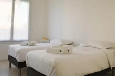 two beds in a room with white sheets and pillows at IMMOGROOM - SEA VIEW - 2 min from beach - CONGRESSBEACHES in Cannes