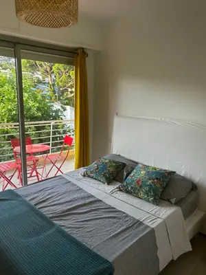 a bed with two pillows in a bedroom with a balcony at Modern cosy two bedrooms in Cannes , large terrace, 5 minutes from Croisette in Cannes