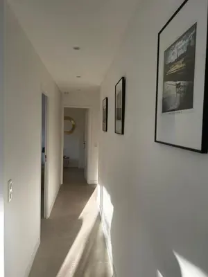 a hallway with white walls and pictures on the wall at Modern cosy two bedrooms in Cannes , large terrace, 5 minutes from Croisette in Cannes