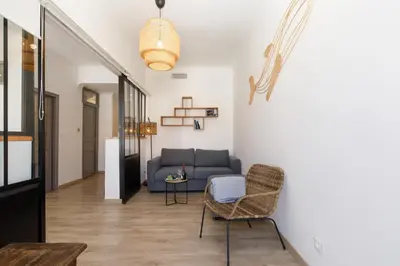 a living room with a couch and a table at La Colline YourHostHelper in Cannes