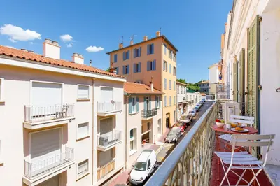 a balcony with a view of a street with buildings at La Colline YourHostHelper in Cannes