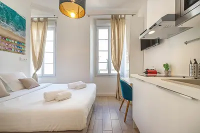 a bedroom with two beds and a kitchen at Agences des Résidences - Rue Commandant André in Cannes